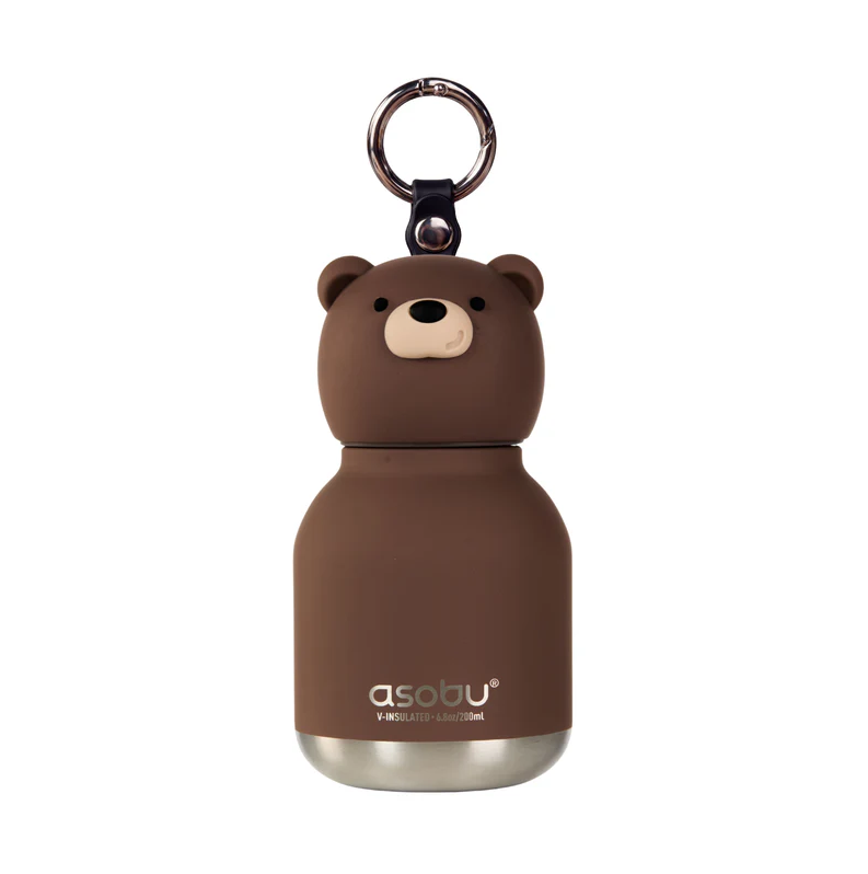 The Mini Brown Bear Bestie Bottle Vacuum Flask by Asobu Bottle (AdnArt Inc) is a small, insulated kids flask designed in the shape of a bear, featuring a cute face, rounded ears, and a metal keychain on top. With “asobu” printed on the front near the bottom, this adorable and practical bottle is perfect for keeping drinks at the ideal temperature while on the go.