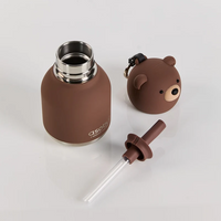 The Mini Brown Bear Bestie Bottle Vacuum Flask by Asobu Bottle/AdnArt Inc features a cute brown insulated design with a metal rim, a bear-shaped lid, and a convenient straw attachment. Perfect for little ones who love adorable animal-themed designs, this charming vacuum flask is shown placed on a white surface.