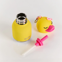 The Asobu Bottle/AdnArt Inc Mini Duck Best Bottle Vacuum Flask is a yellow insulated kids’ flask with a stainless steel opening, featuring an adorable animal design. Its duck-shaped cap comes complete with a pink bow and beak, and it includes a matching pink straw attachment placed beside the flask—all displayed on a clean white background. This vacuum-insulated stainless steel flask keeps your child’s drinks at the perfect temperature.