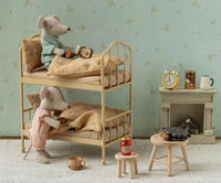 Two Maileg mice in pajamas enjoy a warm bedtime scene on bunk beds in a cozy, vintage-style room, complete with the Maileg Waffle set, Mouse by Maileg, as well as tea, snacks, books, a clock, a stove, and charming miniature furniture for imaginative pretend play.