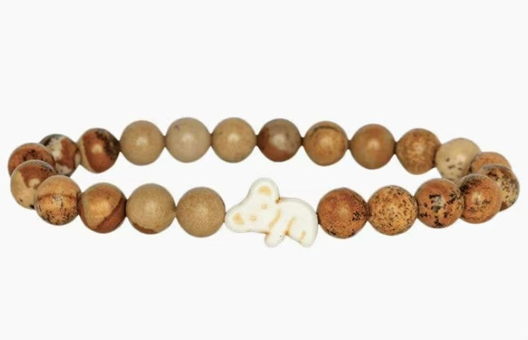 The Lounge - Dune Kaola bracelet by fahlo features round, brown-toned beads with a white koala accent, beautifully arranged in a circle on a plain white background—ideal for supporting wildlife conservation.