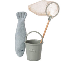 The Maileg Fishing Set, Mouse by Maileg includes a grey fabric fish, a small green Maileg bucket, and a toy fishing net with wooden handle—perfect miniature fishing accessories for your Maileg Mouse.