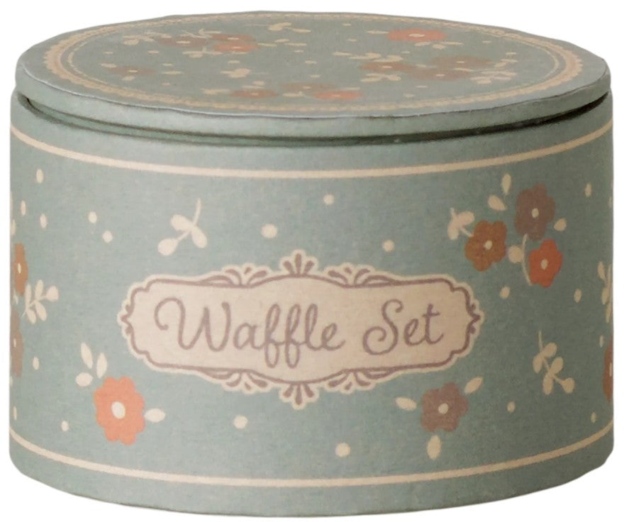 A round, pastel green box featuring a floral pattern and a decorative label reading “Maileg Waffle set, Mouse” on the side makes an ideal addition to pretend play with Maileg mice. The matching lid complements the box’s charming design, making this miniature set by Maileg both delightful and perfect for imaginative adventures.