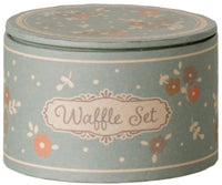 A round, pastel green box featuring a floral pattern and a decorative label reading “Maileg Waffle set, Mouse” on the side makes an ideal addition to pretend play with Maileg mice. The matching lid complements the box’s charming design, making this miniature set by Maileg both delightful and perfect for imaginative adventures.