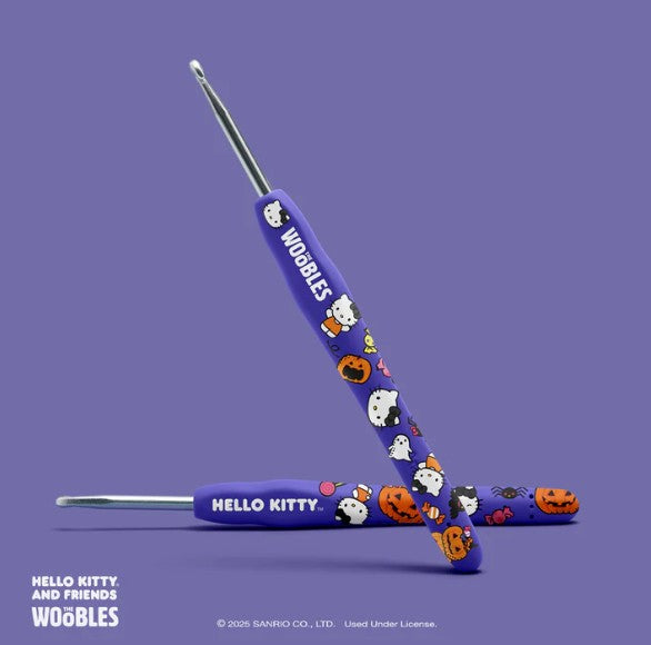 Two purple crochet hooks from The Woobles' Halloween Hello Kitty Crochet Kit, decorated with Hello Kitty, bats, pumpkins, and stars—perfect for a spooky crochet project.