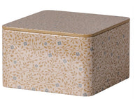 The Maileg Metal box - Branches by Maileg is a square tin box with rounded edges, featuring an elegant pattern of gold vines and small blue flowers on a beige background. This decorative metal storage box comes with a fitted lid, making it perfect for organizing small treasures or presenting thoughtful gifts—an ideal choice for storage or gifting needs.