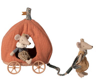 Two Maileg Mouse toys dressed in crowns and clothes play with the Maileg Pumpkin Carriage, Mouse—one pulls it by a fabric strap while the other enjoys a ride inside the soft, orange carriage.