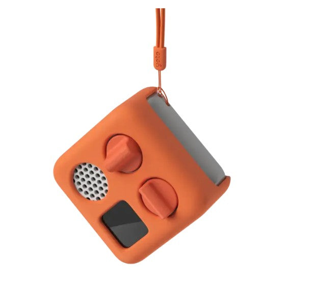 The Yoto Mini Adventure Jacket - Fruit Punch by Yoto is a durable, orange silicone sleeve designed to fit the square-shaped Yoto Mini, protecting its speaker, screen, knobs, and lanyard for extra durability.