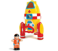The Smart Toys Ronnie Rocket stands upright with vibrant red, yellow, and white details. In front is a cheerful astronaut in an orange suit with a black helmet and white gloves—perfect for imaginative play.