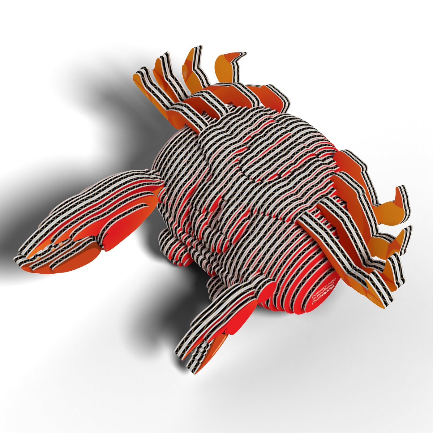 The EUGY Crab 3D Puzzle by Eugy features a stylized crab design crafted from layered, striped materials in black, white, orange, and red. Reminiscent of a STEM craft kit, this playful sculpture casts an eye-catching shadow on a white surface.