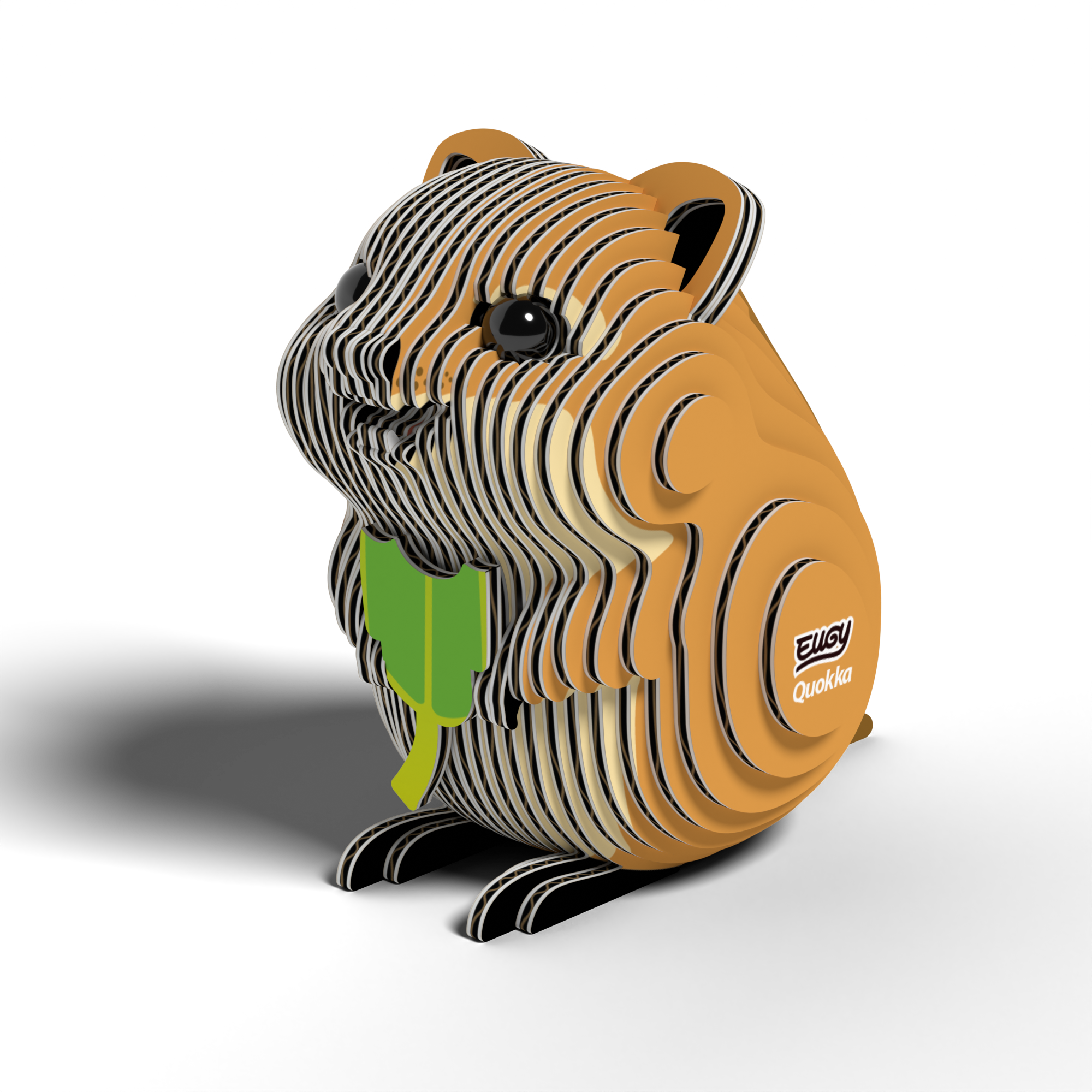 The EUGY Quokka 3D Puzzle by Eugy is an eco-friendly model featuring an orange and tan quokka with black eyes, holding a green leaf. Its body is crafted from stacked, curved segments for a striped, wood-like appearance, and the side is labeled "Quokka.