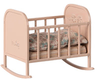 The Maileg Cradle, My - Light Rose by Maileg is a small pink cradle with floral details, featuring a patterned pillow and blanket—ideal for pretend play or as an adorable miniature addition to any dollhouse.