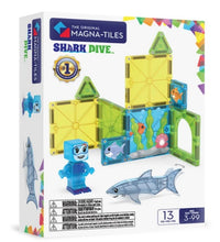 The Magna-Tiles Shark Dive 13-Piece Set by Magna-Tiles features a magnetic building set with vibrant tiles, a sea-life-themed background, a blue diver figure, and a shark figure. Designed for ages 3 to 99, this set encourages imaginative underwater play.