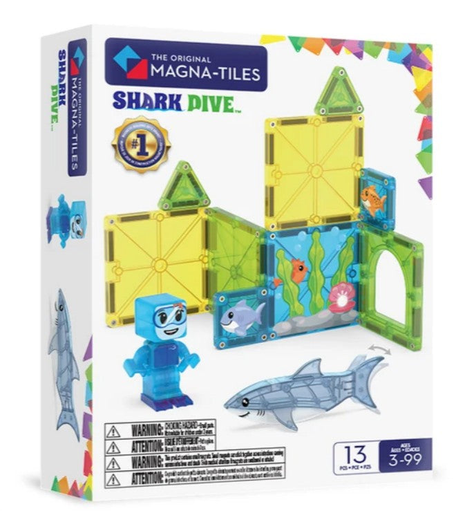 The Magna-Tiles Shark Dive 13-Piece Set by Magna-Tiles features a magnetic building set with vibrant tiles, a sea-life-themed background, a blue diver figure, and a shark figure. Designed for ages 3 to 99, this set encourages imaginative underwater play.