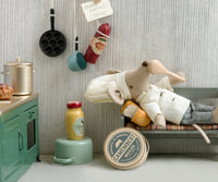 The Maileg Chef Mouse W. Soup Pot And Spoon, Big Brother by Maileg relaxes in a cozy kitchen scene, ready for imaginative play and pretend meals with included cooking accessories.