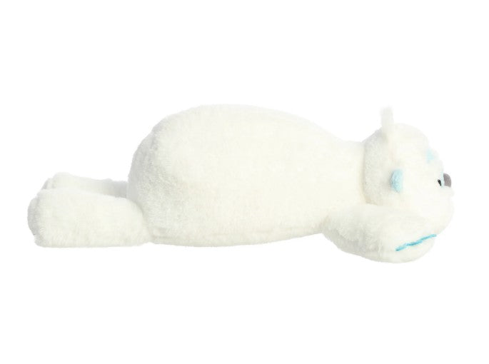 An 18" Snoozles Yeti plush by Aurora lies flat on its stomach with extra-soft white fur, light blue accents on its face and paws, and outstretched legs—making it the perfect cuddly companion.