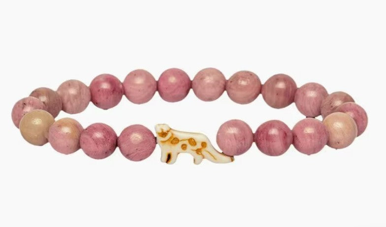The Ascent - Wildflower Pink Snow Leopard bracelet by fahlo features round pink and mauve beads with a white, brown-spotted snow leopard charm—an ideal accessory for wildlife conservation enthusiasts.