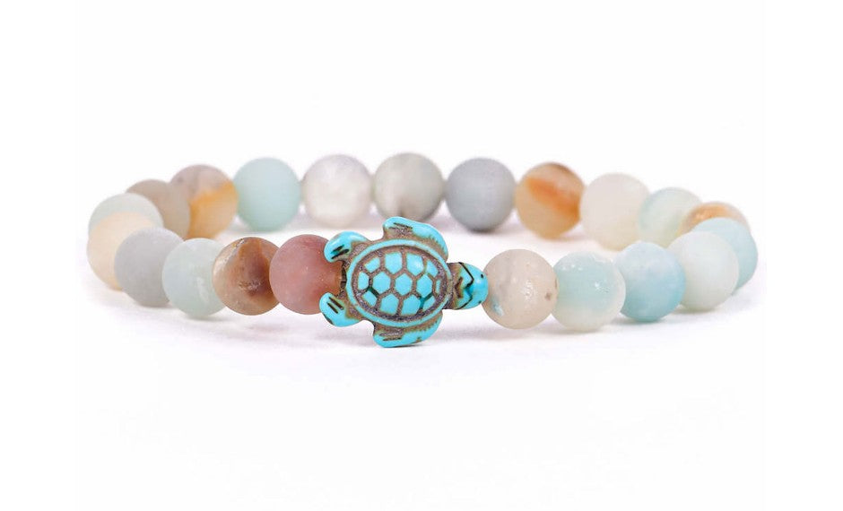 The fahlo Journey - Sky Stone Sea Turtle bracelet features pastel beads and a central turquoise turtle bead, displayed on a white background. Ideal for marine conservation enthusiasts.