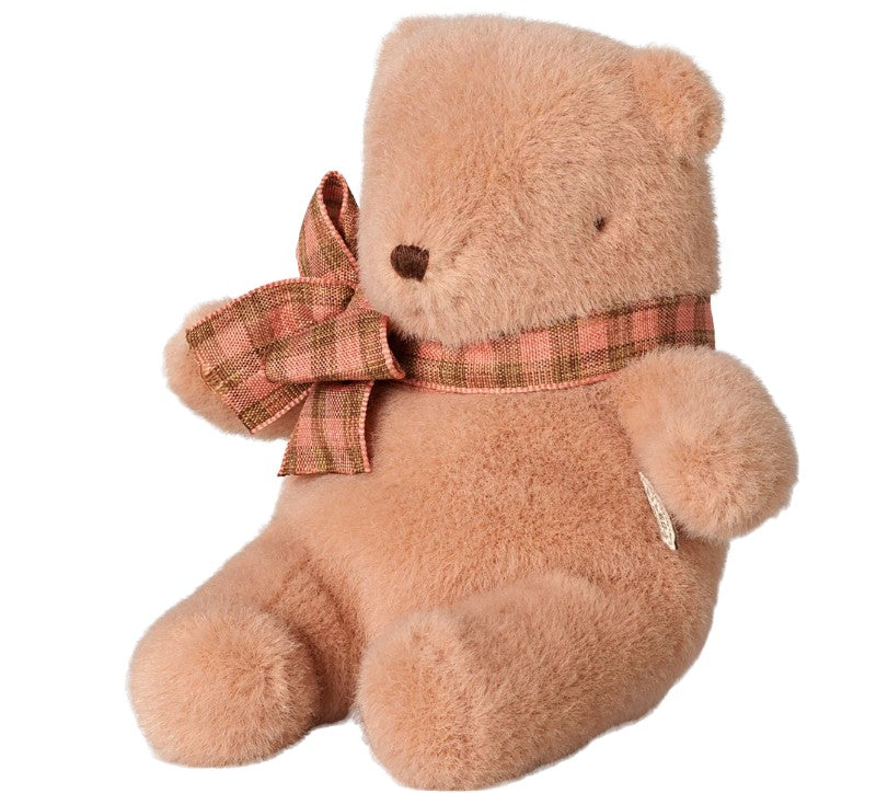 A plush Mini Maileg Teddy bear in vintage rose, wearing a plaid bow around its neck, sits upright facing slightly left against a white background—a charming addition from Maileg.