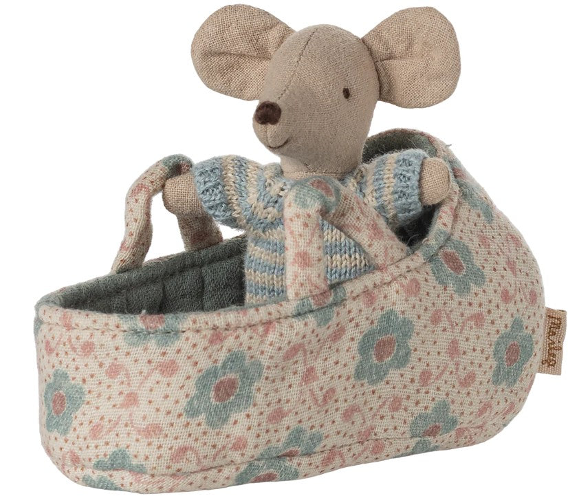 The Maileg Baby Mouse In Carry Cot - Blue by Maileg features a tiny mouse in a striped sweater nestled inside a blue floral fabric carry cot with soft handles.