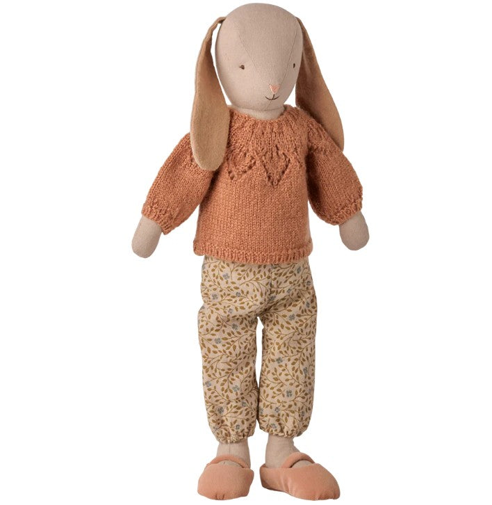 A Maileg stuffed bunny doll dressed in the Maileg Pants and Knitted Sweater, Size 3 - Vintage Powder, featuring a rust-colored knitted sweater set paired with vintage powder pants and soft shoes. The bunny, from the Maileg brand, is designed with long floppy ears, a gentle expression, and is perfectly sized to wear Maileg Size 3 clothing.