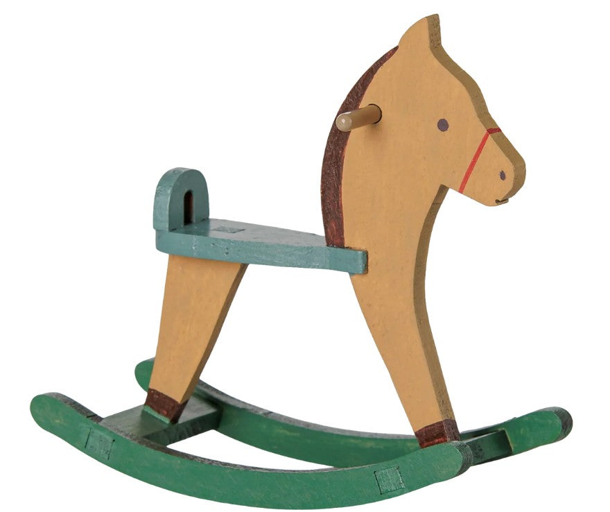 The Maileg Rocking Horse, Mouse - Light Brown by Maileg features a wooden rocking horse toy with a tan body, green base, green seat, and simple painted facial details—perfect as a charming nursery toy or as an adorable miniature rocking horse accessory for your Maileg mice collection.