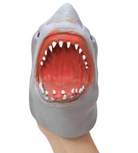 A hand displays the Schylling Toys Shark Hand Puppet, featuring a realistic gray design with its mouth wide open to reveal sharp white teeth and a red interior, set against a white background—ideal for puppet shows or imaginative play.