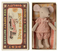 The Maileg Big Sister Mouse In Matchbox by Maileg features a small mouse in pink pajamas lying in a matchbox bed decorated with “Mouse Race,” “Grand Old Match Factory,” and a colorful racing car illustration.