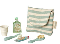 The Maileg Toothbrush Set In Bag, Mouse - Blue Stripe features a striped pouch with mini toiletries—shampoo, cup, toothbrush set, toothpaste, and hairbrush—ideal for dollhouse play with your Maileg mouse.