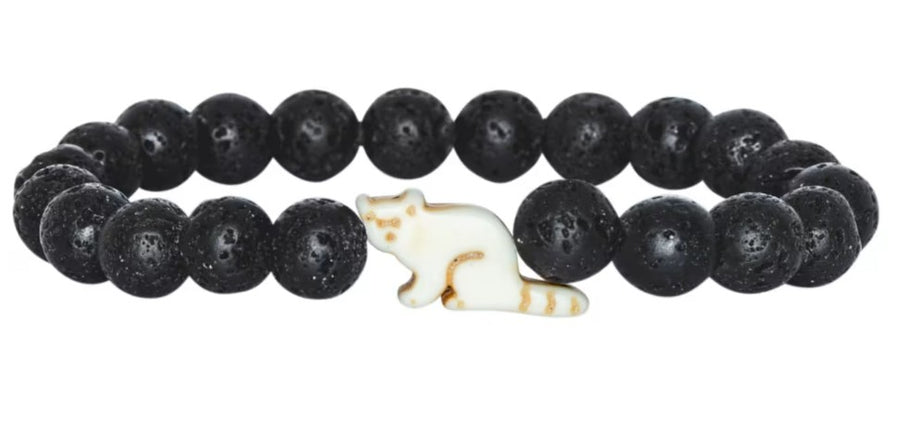 Introducing Dash - Lava Stone Red Panda by fahlo: a beaded bracelet featuring round, black lava beads and a white ceramic bead shaped like a sitting cat—an accessory inspired by wildlife conservation, perfect for any red panda bracelet collection.