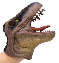A person’s hand is inside the Schylling Toys Dinosaur Hand Puppet, designed to resemble a realistic T. rex with an open mouth displaying sharp teeth and a red tongue. Featuring brown textured skin and a yellow eye, this puppet is perfect for imaginative play and storytelling.