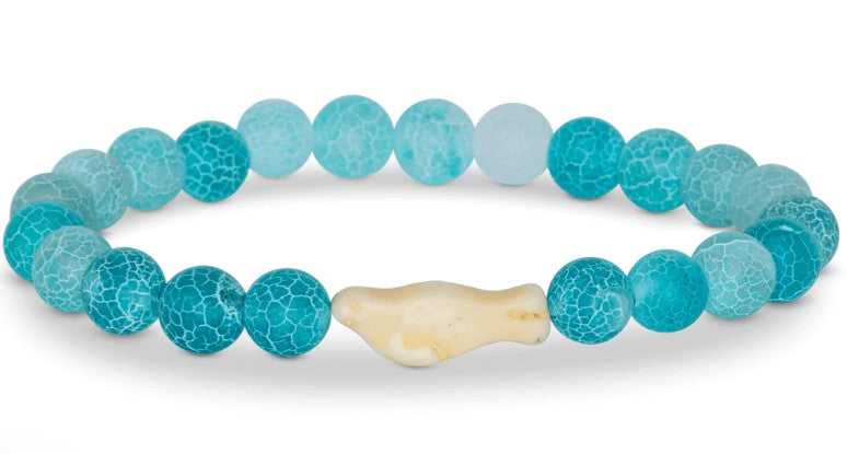 The fahlo Glide - Aqua Blue Seal is a beaded bracelet featuring crackled turquoise-blue beads and a central cream-colored seal bead, inspired by wildlife conservation.