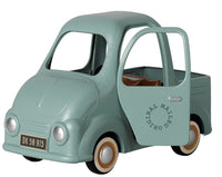 A small, mint green Maileg Truck, Mouse with an open door, brown seats, and white-rimmed wheels. Perfectly sized for mice, this miniature truck by Maileg features “Original Maileg” on the side and a DK 56 915 license plate.