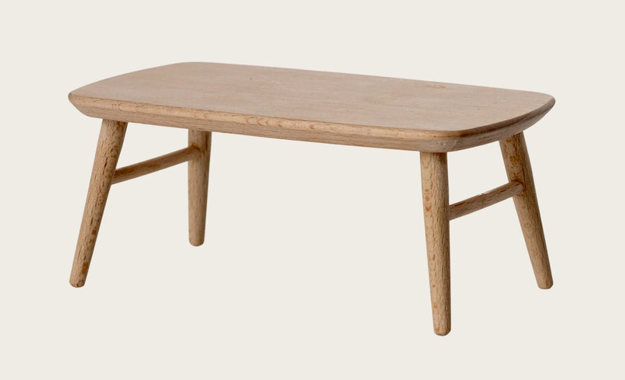 The Maileg Coffee Table, Mouse - Nature by Maileg is a small, light wood table with rounded edges and four angled legs, displayed against a plain light background.