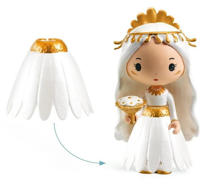 The DJECO Tinyly Marguerite & Leopold figurine features long white hair and wears a detachable white dress with gold accents that resembles flower petals, as highlighted by an arrow indicating the removable skirt. This miniature collectible from DJECO comes with a gold and white accessory, making it perfect for imaginative play.