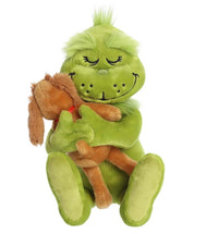 A fuzzy, green Holiday Hugs plush by Aurora features a smiling Grinch with closed eyes hugging a brown plush dog. Both are seated together, and the Grinch’s tuft of green hair adds to their festive charm—making this adorable duo a perfect holiday gift for fans of cuddly toys.
