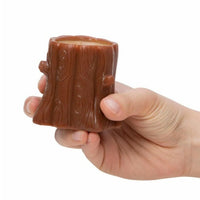 A hand holding the Nutty Squirrel Popper by Schylling Toys, a small, brown, tree stump-shaped cup with realistic wood grain details against a white background—an adorable squirrel sensory toy and unique fidget toy for stress relief.