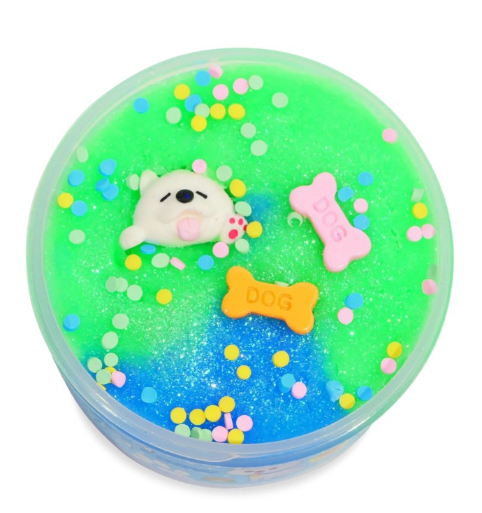Peachybbies Slime's Puppy Chow Slime comes in a round container filled with green and blue handmade slime, glitter, vibrant confetti, a cute white dog figurine, and two bone-shaped DOG charms on top—perfect for a playful Puppy Chow sensory experience.