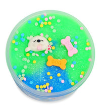 Peachybbies Slime's Puppy Chow Slime comes in a round container filled with green and blue handmade slime, glitter, vibrant confetti, a cute white dog figurine, and two bone-shaped DOG charms on top—perfect for a playful Puppy Chow sensory experience.