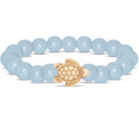 The fahlo Journey - Aqua Glow Sea Turtle bracelet features round light blue beads and a small beige turtle charm at the center, inspired by sea turtle conservation.