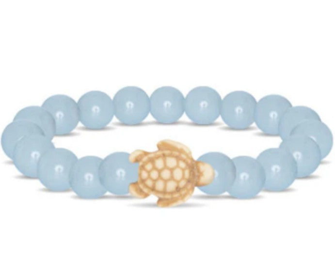 The fahlo Journey - Aqua Glow Sea Turtle bracelet features round light blue beads and a small beige turtle charm at the center, inspired by sea turtle conservation.