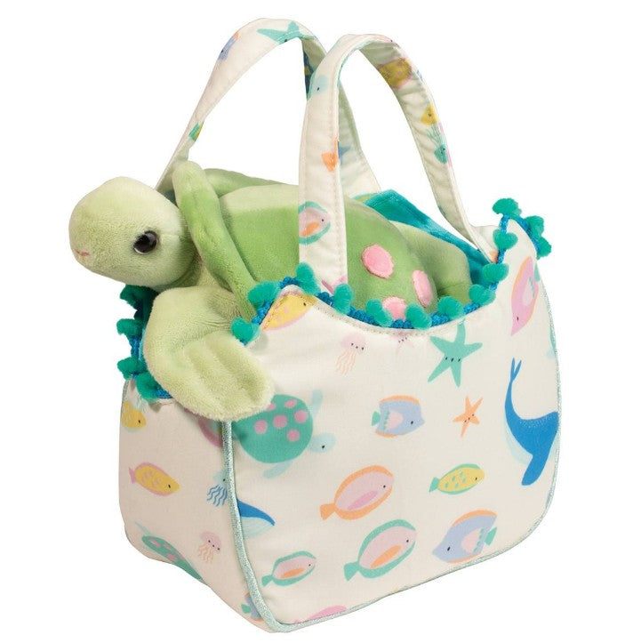 The Douglas Ocean Friends Sassy Sak w/Turtle features a plush turtle in a soft, white tote adorned with colorful sea creatures, teal pom-pom trim, and two handles—perfect for inspiring nurturing play.