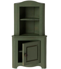The Maileg Corner Cabinet, Mouse - Dark Green by Maileg is a small wooden cabinet for dollhouse storage, featuring an open top shelf and a lower door that reveals an inner shelf—perfect for organizing miniature mouse accessories.