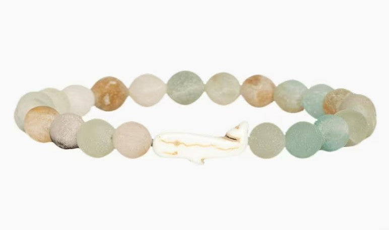 The fahlo Wayfare - Dune Whale bracelet features round, pastel stones and a central white whale-shaped bead on a white background—a stylish tribute to marine conservation.