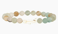 The fahlo Wayfare - Dune Whale bracelet features round, pastel stones and a central white whale-shaped bead on a white background—a stylish tribute to marine conservation.