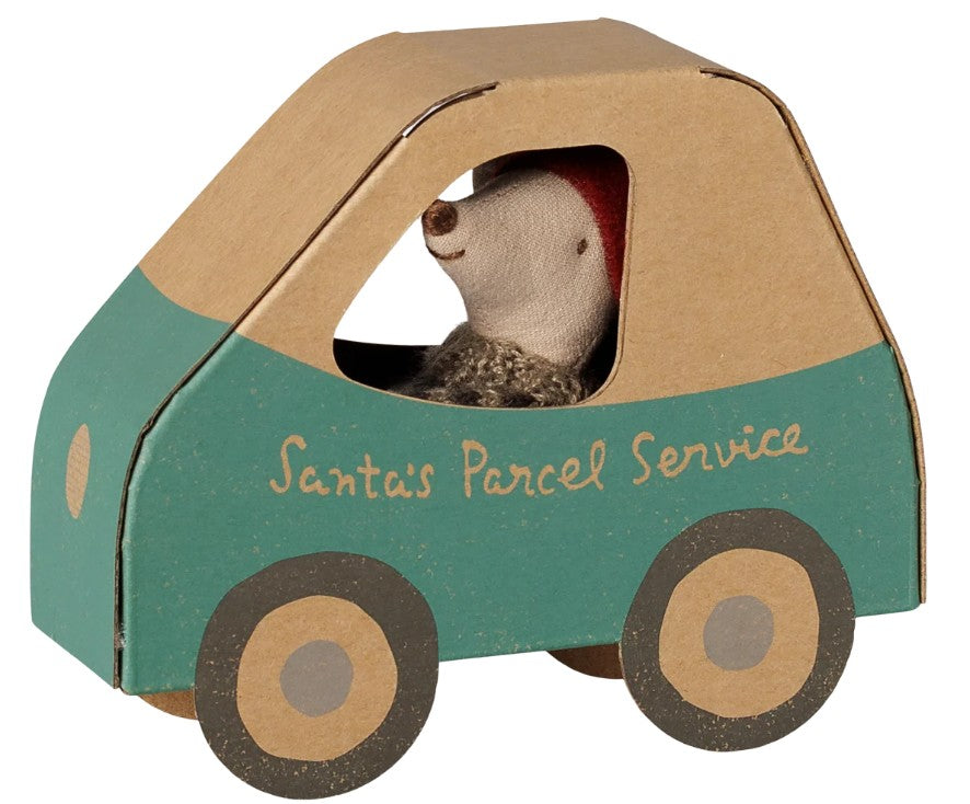 A small Maileg Christmas mouse—Little Brother in a car box—wears a red hat and sits inside a festive green and brown cardboard vehicle, making it ideal for imaginative holiday play and storytelling.