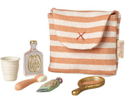 The Maileg Toothbrush Set In Bag, Mouse - Coral Stripe features a striped pouch and includes a toy cup, Flora Parfum bottle, brush, tube, and gold hand mirror—ideal Maileg accessories for pretend play.