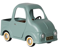 The Maileg Truck, Mouse by Maileg is a light blue vintage-style miniature pickup truck featuring a small bed, round headlights, whitewall tires, and a black license plate marked DK 56 915. Designed to be mouse-sized, this charming vehicle has no windows or visible seats.