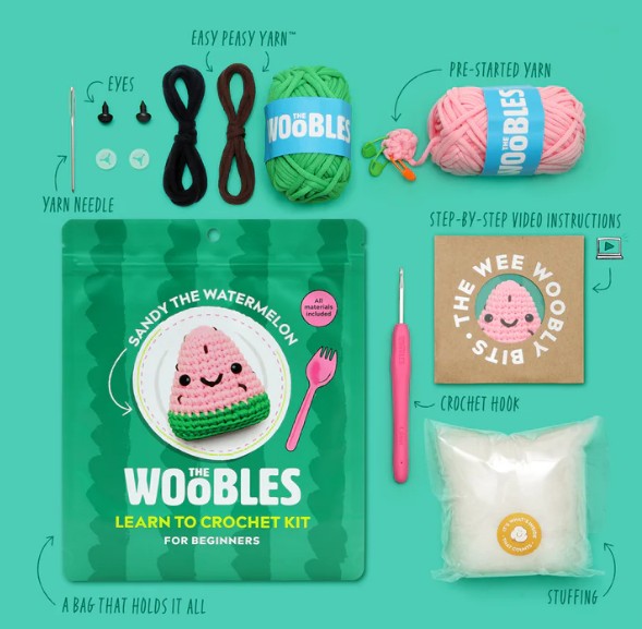 The Woobles Sandy the Watermelon Crochet Kit for beginners includes yarn, crochet hook, eyes, yarn needle, stuffing, pre-started yarn, step-by-step instructions, and a zippered bag—all neatly organized.