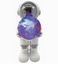 The Fahionit Astronaut Wireless Speaker features a toy astronaut in a white suit holding a balloon adorned with a mesmerizing galaxy pattern—complete with stars and nebulae—reflected in its shiny helmet, making it an enchanting addition to any space enthusiast’s collection or playful astronaut-themed decor.